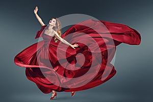 Fashion woman dancing in fluttering red dress