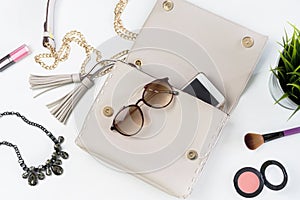 Fashion woman handbag with cellphone, makeup and accessories