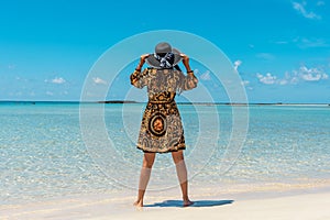 Fashion woman in a hat on a tropical beach. Summer vacation concept