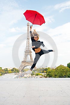 Fashion woman jump with umbrella. Happy woman travel in paris, france. Girl with beauty look at eiffel tower. Travelling