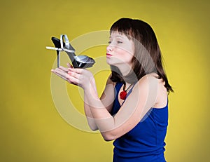 Fashion woman kissing a high-heel shoe. Women love shoes concept. Happy girl and high heels shoes on yellow background. Beautiful