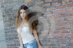 Fashion woman leaning against brick wall