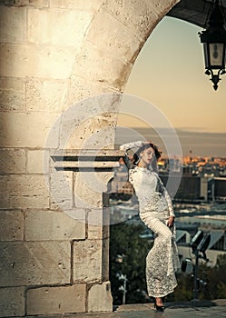 Fashion woman model posing. Beautiful young bride in wedding dress posing on city background