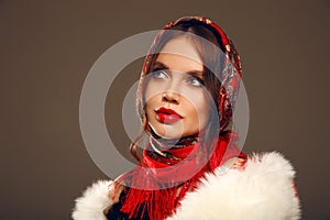 Fashion woman portrait with traditional red headscarf. Russian beauty girl model with red lips makeup isolated on studio