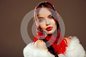 Fashion woman portrait with traditional red headscarf. Russian beauty girl model with red lips makeup isolated on studio