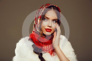 Fashion woman portrait with traditional red headscarf. Russian beauty girl model with red lips makeup and manicured nails 