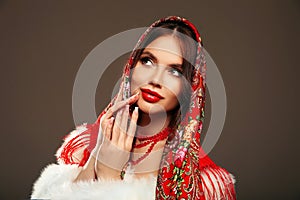 Fashion woman portrait with traditional red headscarf. Russian beauty girl model with red lips makeup and manicured nails 