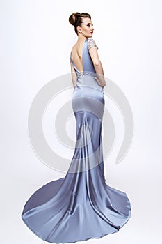 Fashion woman portrait. young model wearing silver evening dress. Hair style back vie