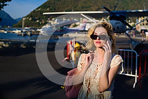 Fashion woman portrait of young pretty trendy girl posing at the city in Europe. Summer street fashion. Woman talking on