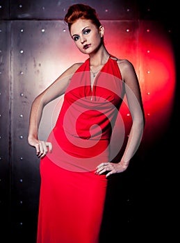 Fashion woman red dress with litle bag. Metal wall background