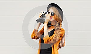 Fashion woman with retro film camera in black round hat