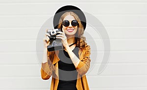 Fashion woman with retro film camera in black round hat