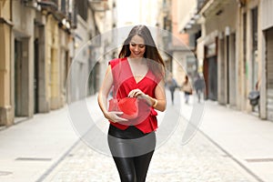 Fashion woman searching in her bag and walking
