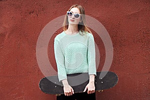 Fashion woman with a skateboard. Girl in sunglasses with longboard
