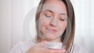Fashion woman smelling cream or face powder, testing make-up