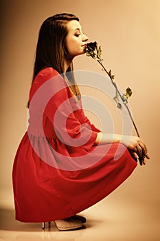 Fashion woman teen girl in red gown with dry rose.