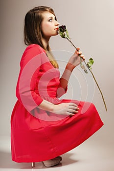 Fashion woman teen girl in red gown with dry rose.