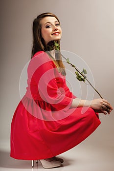 Fashion woman teen girl in red gown with dry rose.