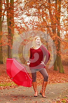 Fashion woman with umbrella relaxing in fall park.