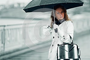 Fashion woman with umbrella walking in a city street