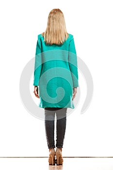 Fashion woman in vivid color green coat rear view