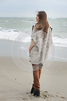 Fashion woman walking alone on a sea beach