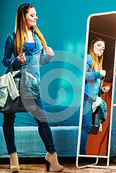 Fashion woman wearing blue denim in front of mirror