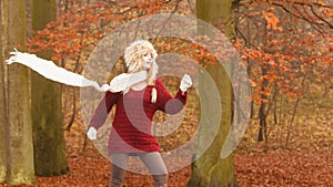 Fashion woman in windy fall autumn park forest.