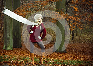 Fashion woman in windy fall autumn park forest.