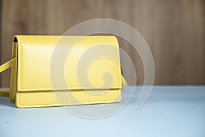 Fashion yellow handbag on blue table