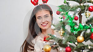 Fashion young beautiful woman in knitted dress near Christmas tree.