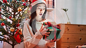 Fashion young beautiful woman in knitted dress near Christmas tree.