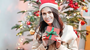 Fashion young beautiful woman in knitted dress near Christmas tree.