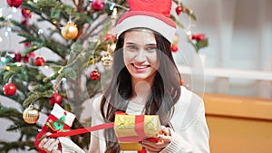 Fashion young beautiful woman in knitted dress near Christmas tree.