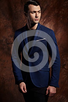 Fashion young man blue suit on brown background