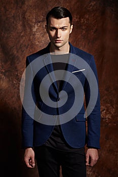 Fashion young man blue suit on brown background