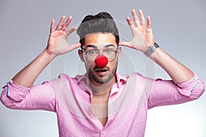 Fashion young man with red nose acting crazy