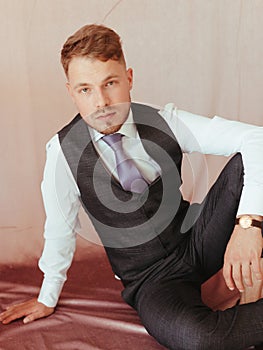 fashion young man wearing black tuxedo, grain effect studio blond