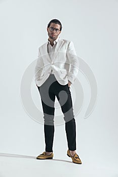 fashion young man with white jacket suit holding hands in pockets