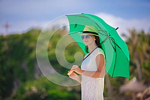 Fashion young woman with green umbrella walking