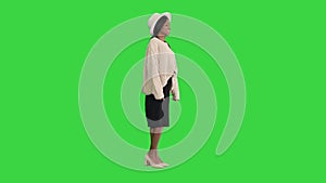 Fashionable african american woman posing in knitwear and white hat on a Green Screen, Chroma Key.