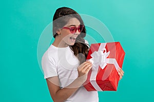 fashionable amazed teen girl in sunglasses open gift box, amazement