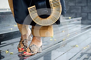 Fashionable bag close-up in female hands.Girl walks in the city outdoors. Stylish modern and feminine image, style. Woman in a dre