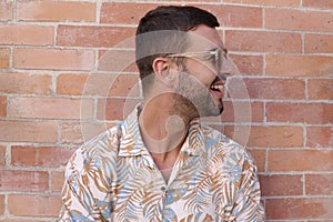 Fashionable bearded man wearing sunglasses and hawaiian style shirt