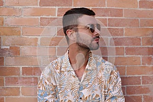 Fashionable bearded man wearing sunglasses and hawaiian style shirt