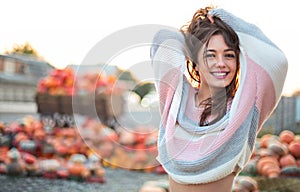 Fashionable beautiful young girl at the autumn pumpkin patch background. Having fun and posing