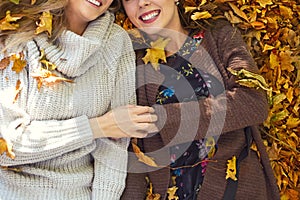 Fashionable beautiful young girlfriends together in the autumn park background. Having fun and posing