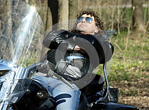 Fashionable biker relax sitting on his motorcycle