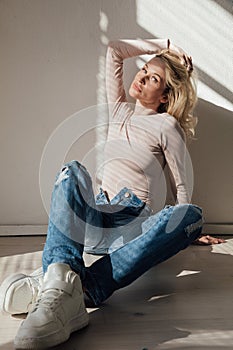 fashionable blonde woman light and shadow from blinds