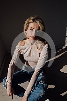 fashionable blonde woman light and shadow from blinds